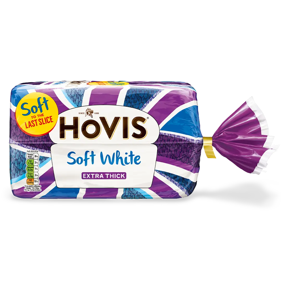 Hovis Soft White Extra Thick Sliced bread with a subtle shadow under it. The packaging features a purple Union Jack pattern and a yellow label reading 'Soft to the Last Slice.'