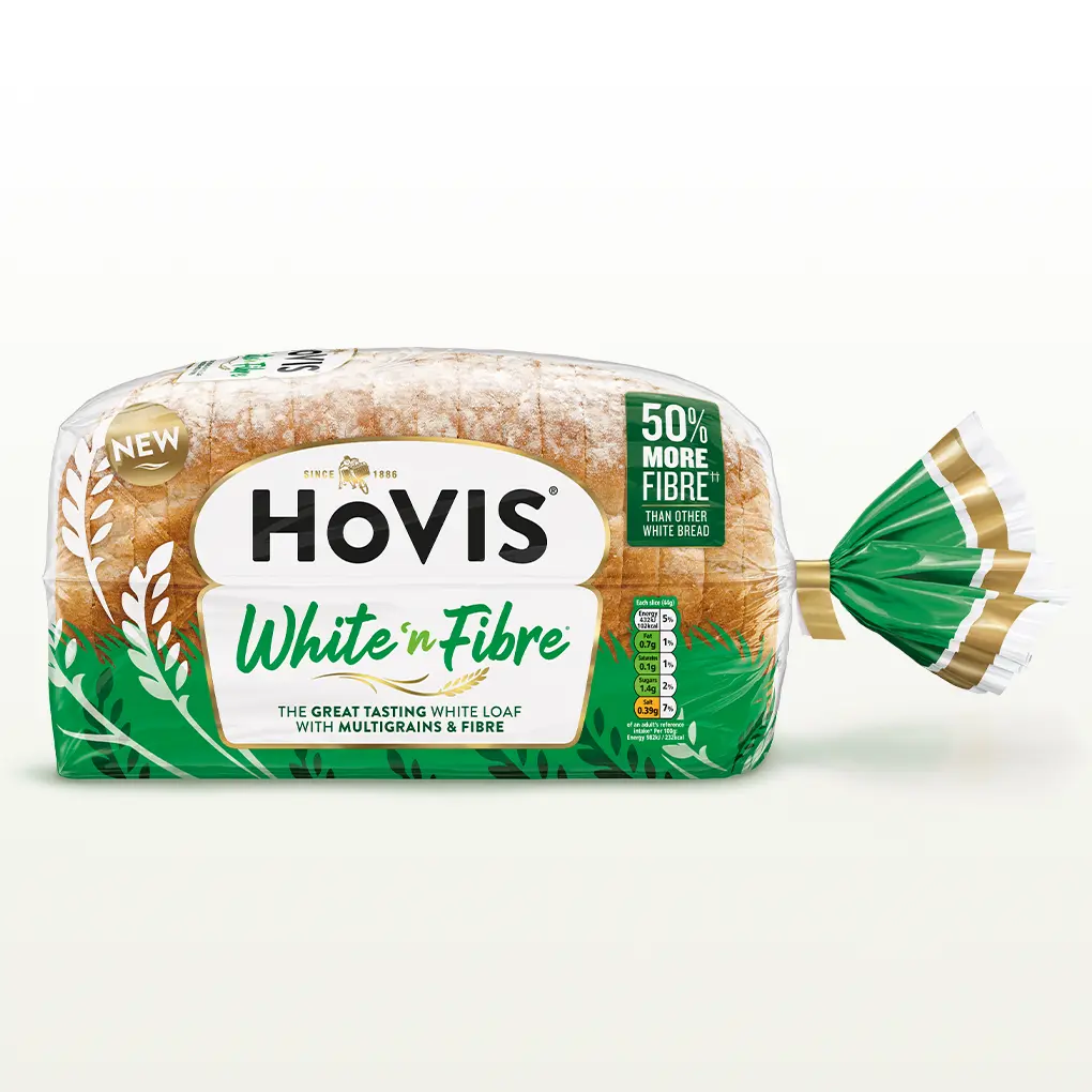 Hovis White n Fibre bread on a white backdrop with a subtle shadow. The packaging is half transparent and green, decorated with wheats.