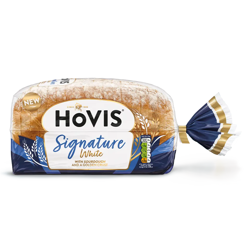Hovis Signature White bread on a white backdrop with a subtle shadow. The packaging is half transparent and with tones of blue, decorated with wheats.