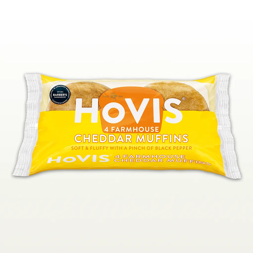 Four Hovis Farmhouse Cheddar Muffins stacked in two piles of two inside a transparent rectangular packaging with the Hovis logo on top.