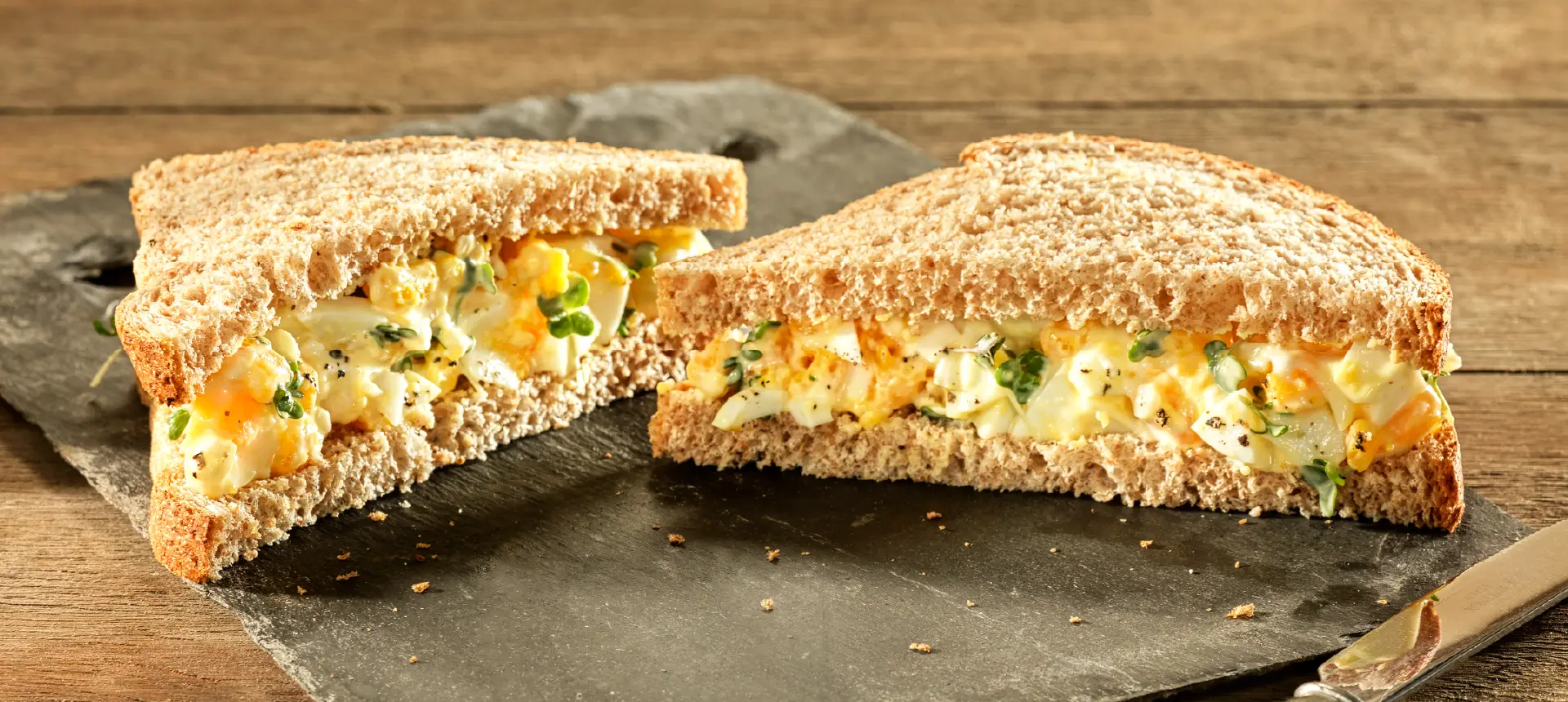 An egg and cress sandwich made with Hovis Nimble Wholemeal bread, sliced in half and filled with a mix of egg, mayonnaise, and cress.