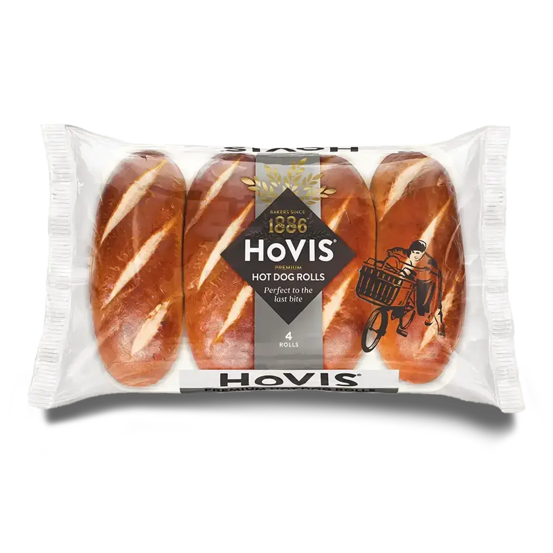 Four Hovis Hot Dog Rolls in a transparent rectangular packaging featuring the Boy on the Bike, a grey stripe, golden wheat, and the Hovis logo on top.