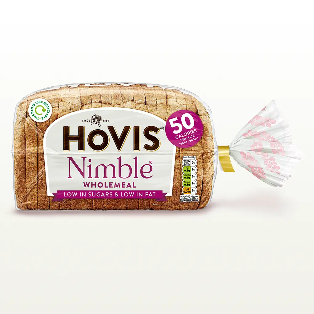 Hovis Nimble Wholemeal bread on a white backdrop with a subtle shadow. The packaging is transparent, decorated with pink wheats, and a magenta label that reads '50 Calories per Slice'