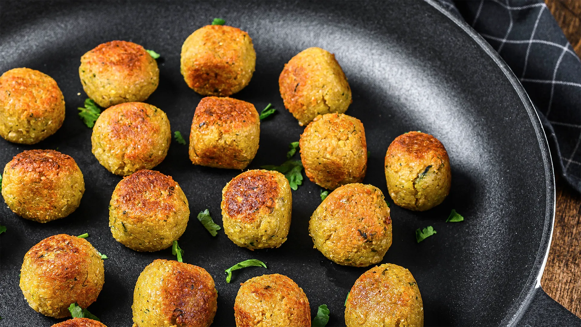 Golden brown falafel cooking on a dry frying pan